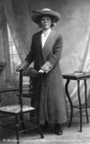 Studio portrait of a young woman wearing a long coat