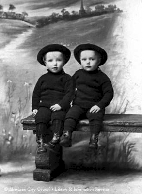 Studio portrait of two young boys on a bench
