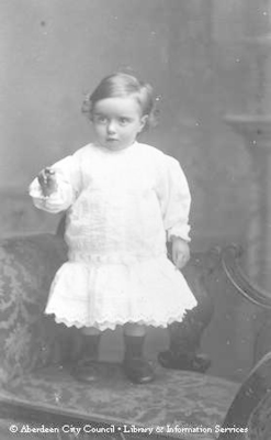 Portrait of baby girl standing on seat