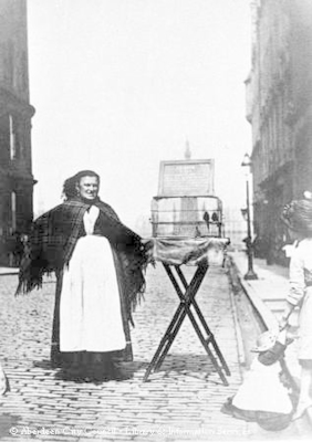 Female trader in the street with cage of birds