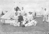 Group portrait of army men relaxing outside tent