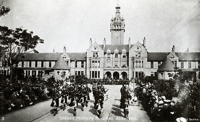 Oldmill Military Hospital. A pipe band parades in front of the main buildings. c.1918.