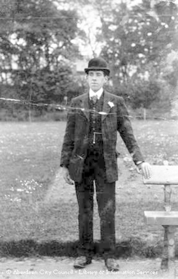 Outdoor portrait of a young man in a suit and bowler hat