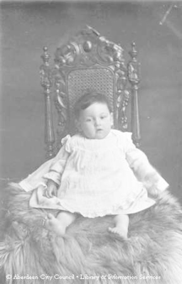 Studio portrait of baby sitting on fur rug