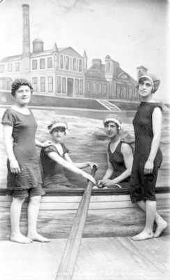 Studio portrait of four ladies beside boat, all wearing swimming costumes